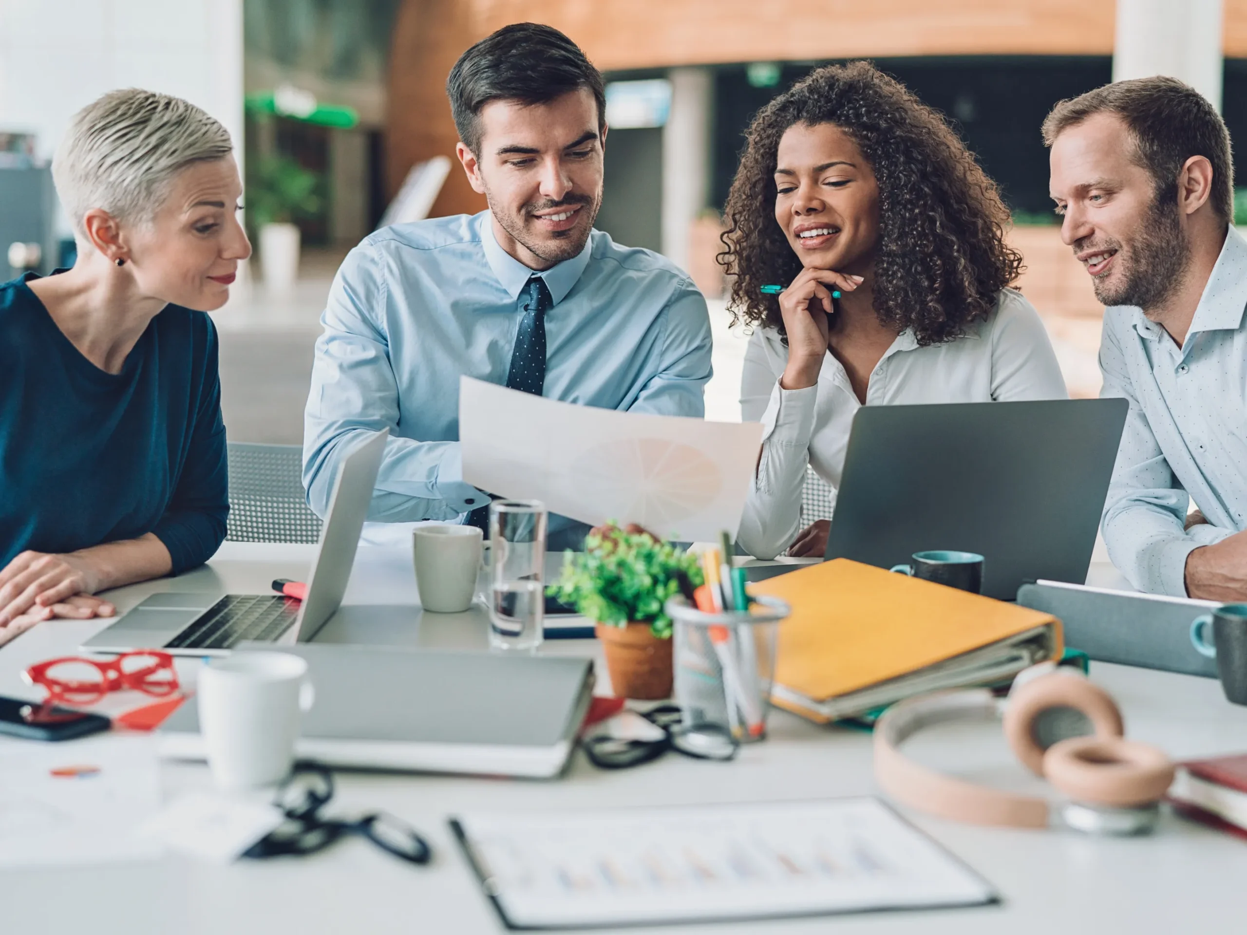business meeting with group of people looking at a paper