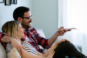 Couple smiles while watching TV