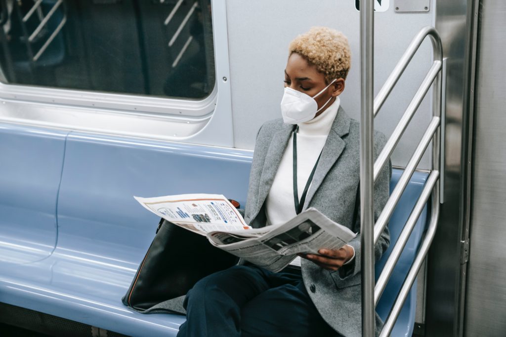 print media- women on subway reading about COVID