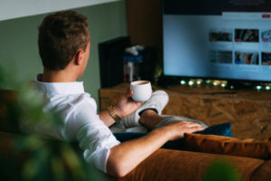 Measure TV Advertising - Back of man sitting on couch watching tv