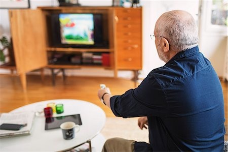 Older Man Sitting In Front Of The Tv