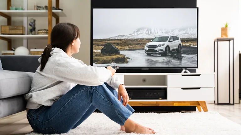 Why Is TV Advertising Effective? - woman sitting in front of tv, watching a car commercial