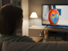 woman watching an tide detergent advertise on local tv
