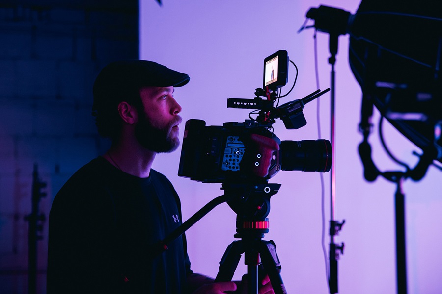 male commercial director standing behind the camera while filming a clip for a tv advertisement