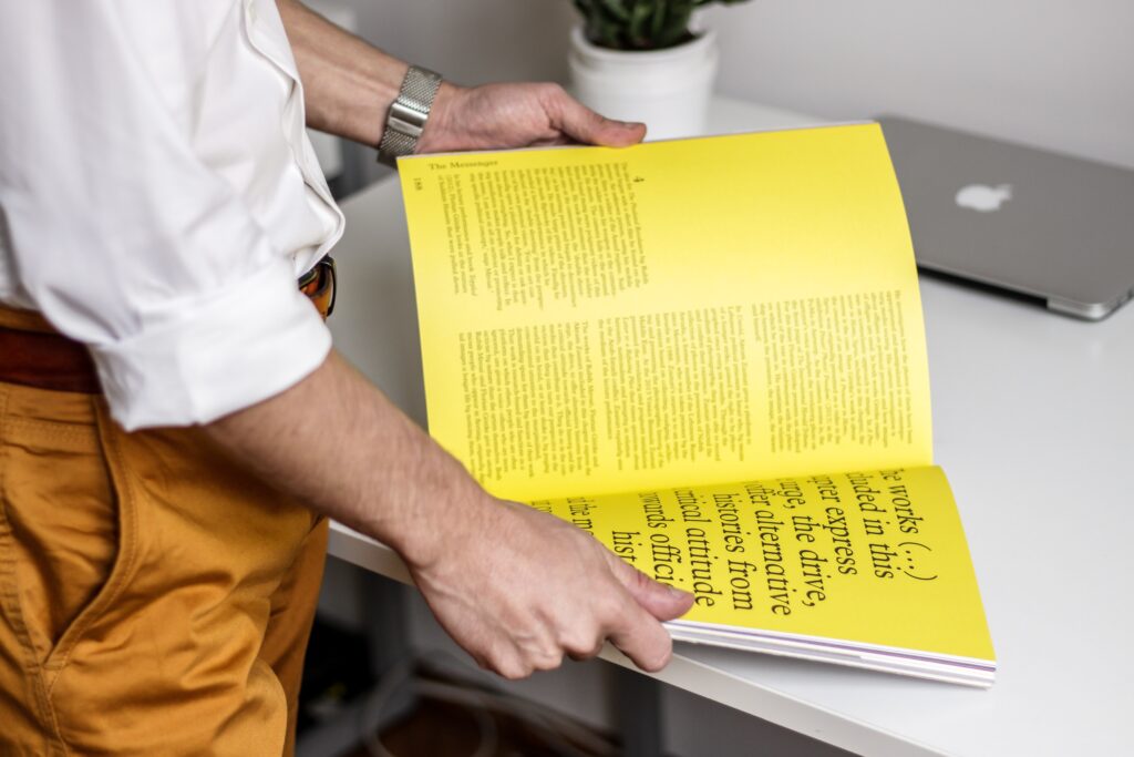 Man standing with typography book open on table