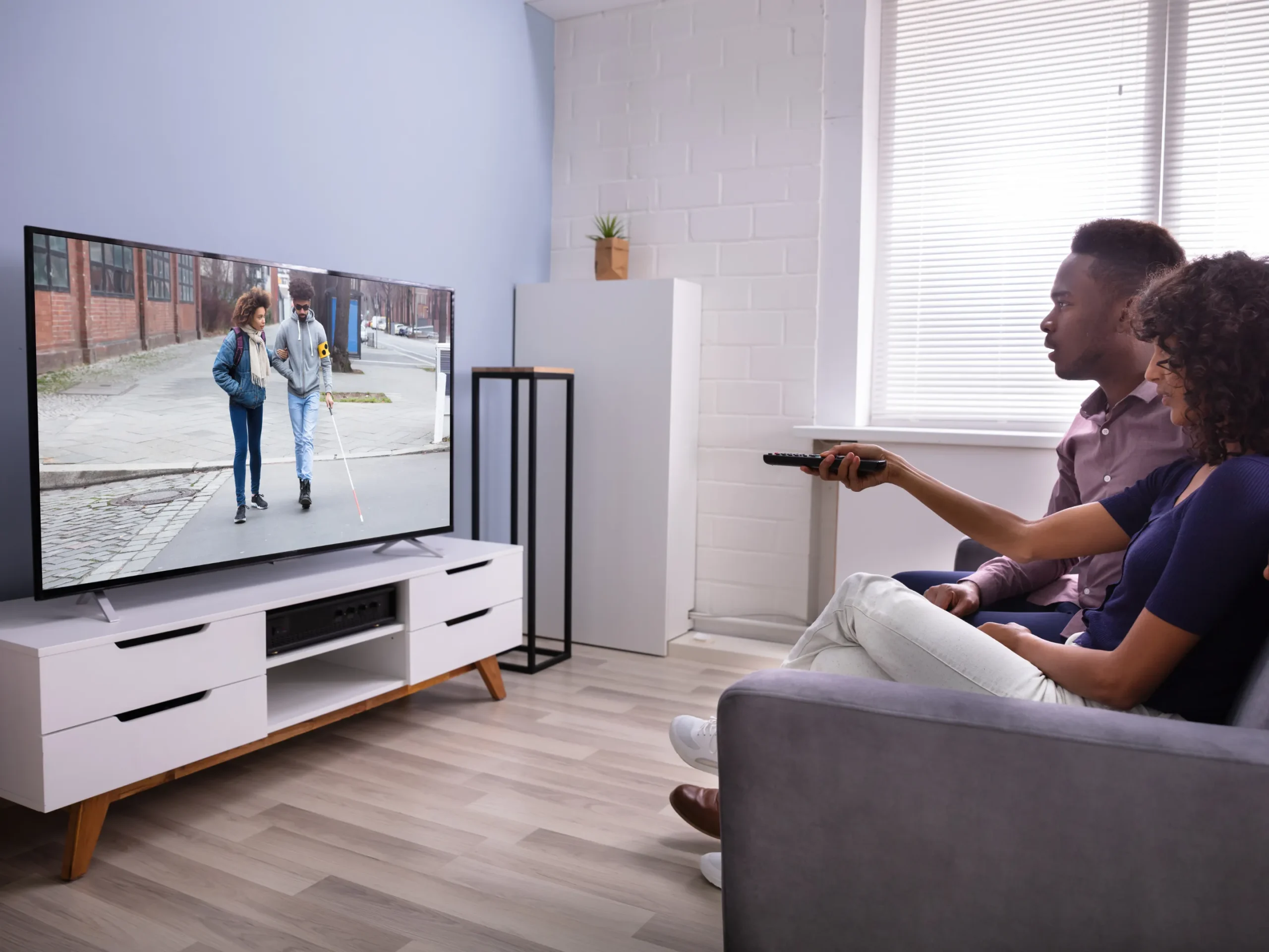 Couple watching television while sitting on couch