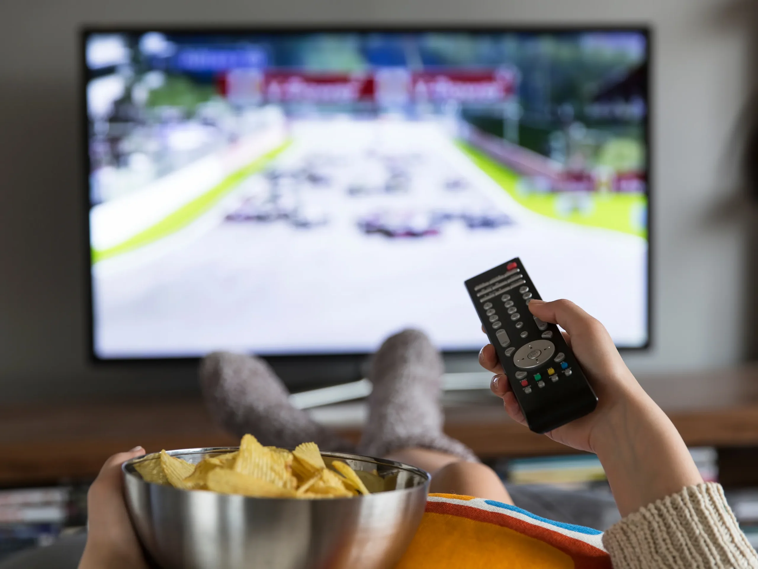 watching tv with chip bowl and remote in hand