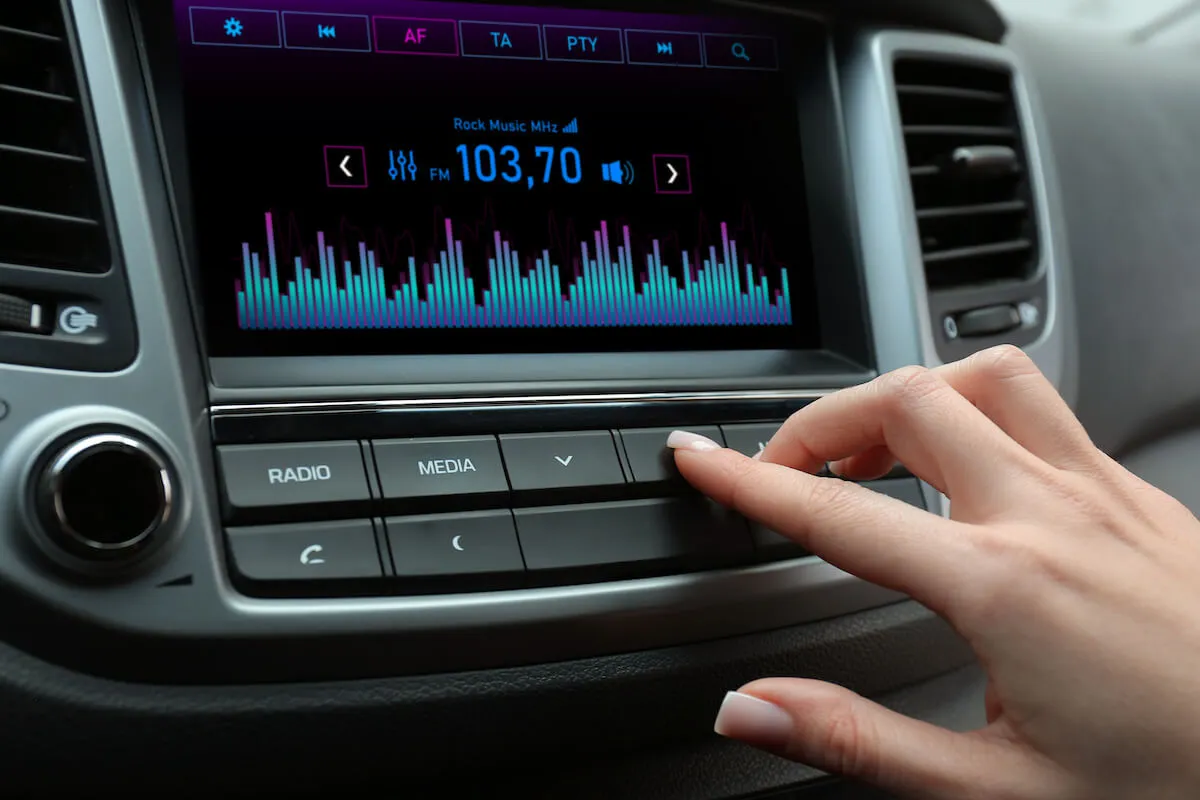 woman turning on the radio in her car