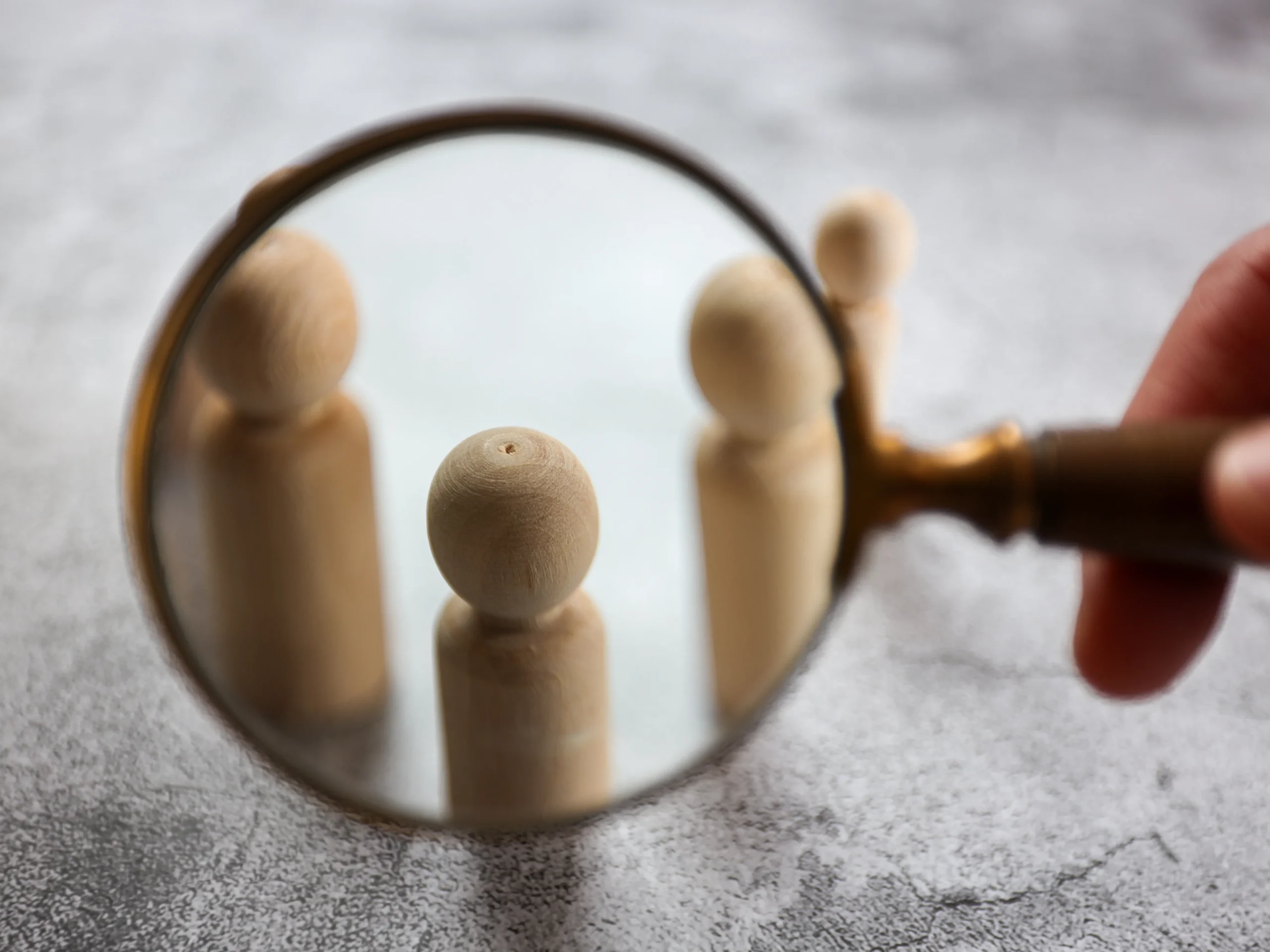magnifying glass on wooden statue to represent a target audience