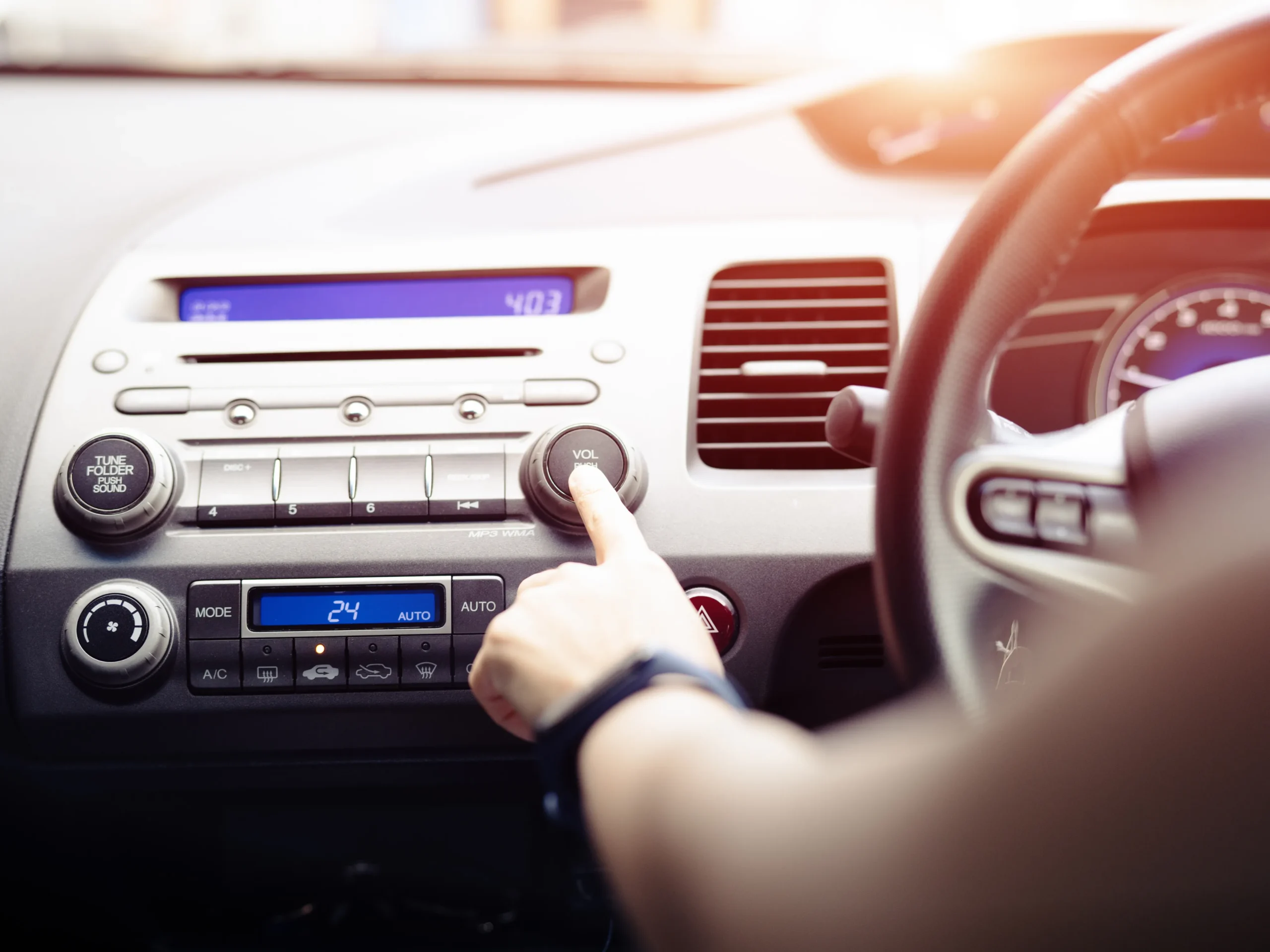 person in car turning on the radio