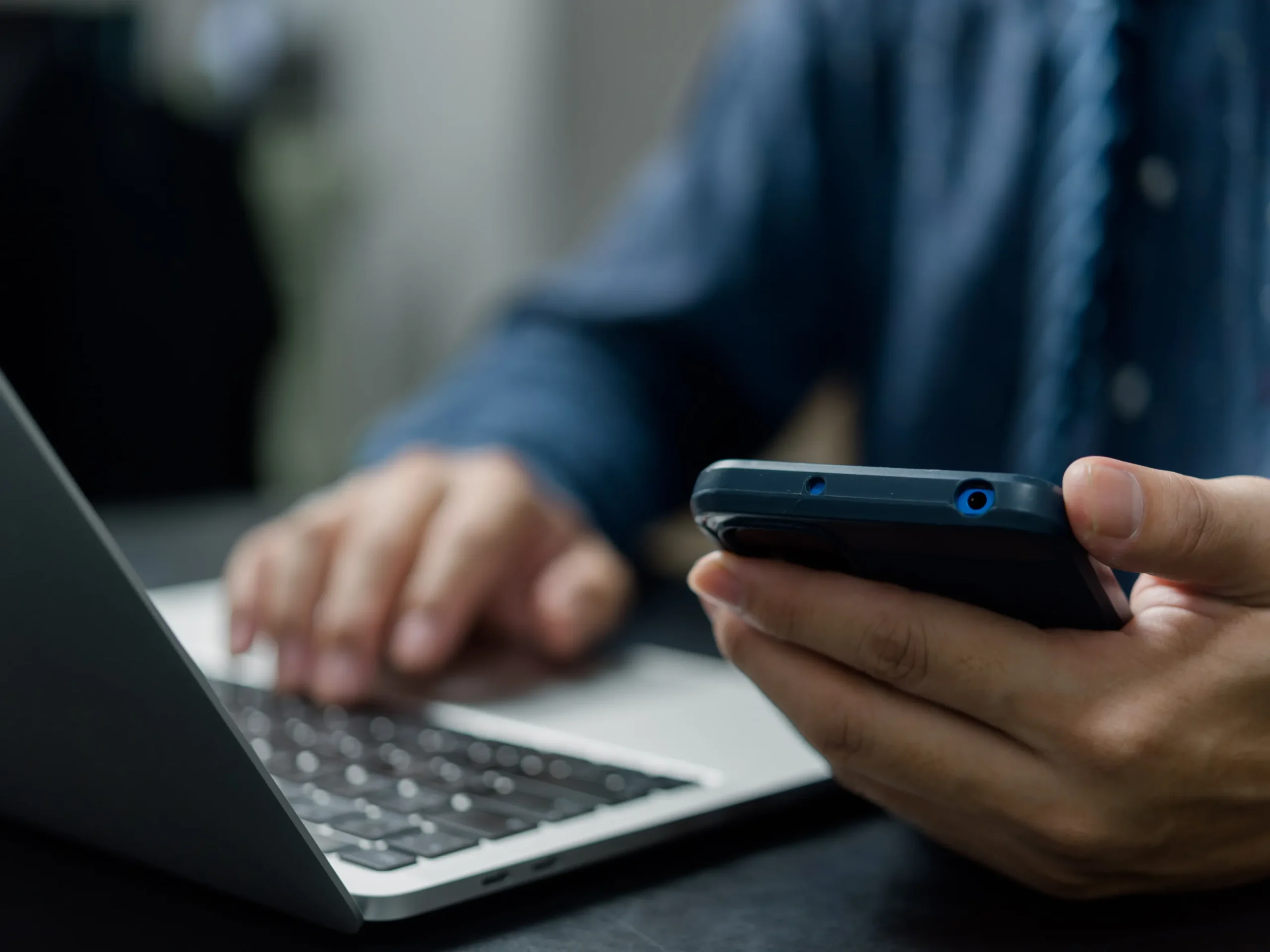 man using laptop and phone - exploring different programmatic advertising platforms