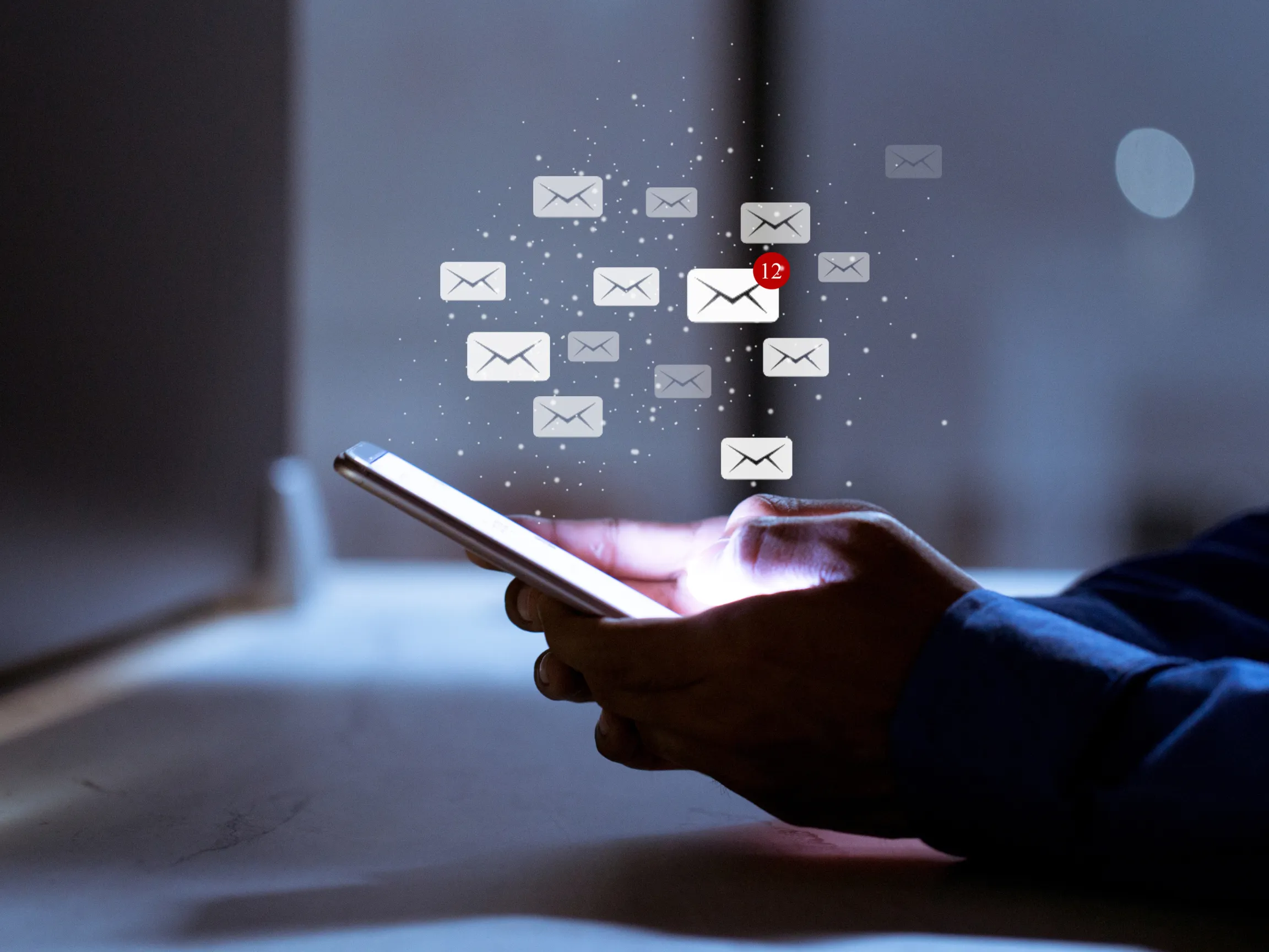 person using phone to send emails - bright phone screen with hovering mail icons
