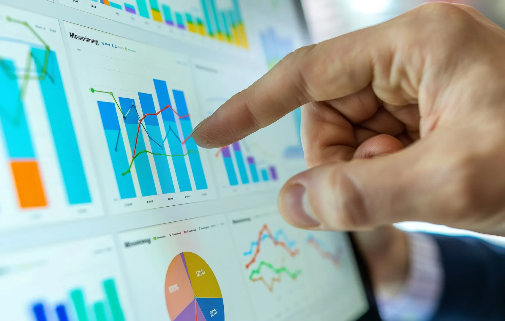Finger pointing to marketing funnel analytics graphs and charts on a computer screen